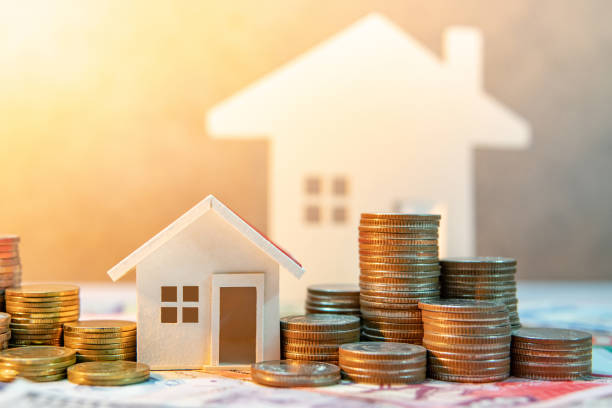 부동산 또는 재산 투자입니다. 주택 담보 대출 비율입니다. 은퇴 개념에 대 한 돈을 절약. 집 모델 테이블에 국제 지폐에 동전 스택. 비즈니스 성장 배경 - loan 뉴스 사진 이미지