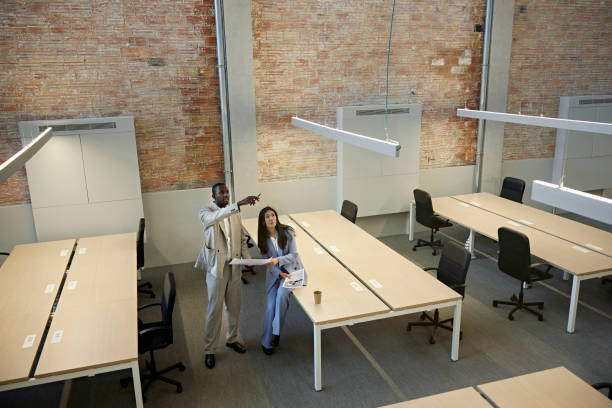 real estate team noting modern office design features - aanwijzen plattegrond stockfoto's en -beelden