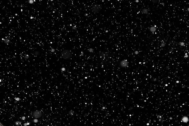 neve che cade reale su uno sfondo nero per l'uso come strato di trama in un disegno fotografico. - snow foto e immagini stock