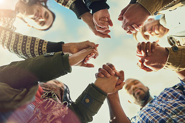 Real friends are there when you need them Shot of a group of friends putting their hands together in prayer christianity stock pictures, royalty-free photos & images
