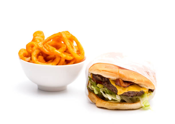 Real Life Hamburger and Seasoned Curly Fries on a White Background Real Life Hamburger and Seasoned Curly Fries on a White Background burger wrapped in paper stock pictures, royalty-free photos & images