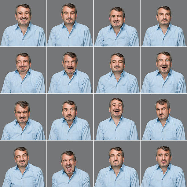 A collection of head shots of the same mature man making sixteen different facial expressions. The man has short gray hair and mustache. He is wearing a light blue shirt. He stands in front of a gray background. The photographs are arranged in four rows of four. The faces range from a simple smile to sad, worried, excited, surprised and silly expressions. 
