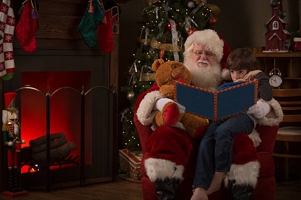 Real Santa Claus reading a story to a young boy Real Santa Claus reading a story to a young boy christmas story telling stock pictures, royalty-free photos & images