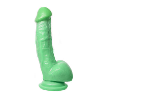 gode vert réaliste avec un scrotum sur une cuvette d'aspiration sur un fond blanc - gode photos et images de collection