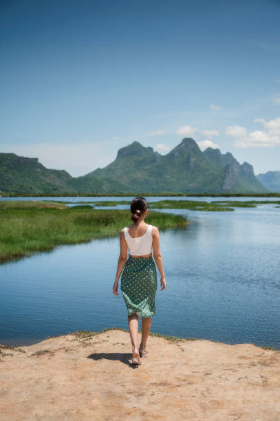 Rear of young asian woman standing with limestone mountain range on wetland at Khao Sam Roi Yot stock photo