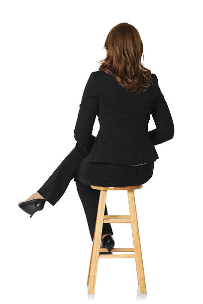 vista posteriore di una donna d'affari seduto su sgabello - accavallare le gambe foto e immagini stock