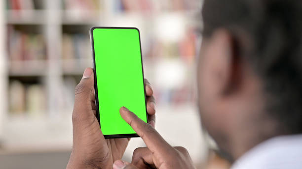 Rear View of African Man using Smartphone, Chroma Screen  smart phone green background stock pictures, royalty-free photos & images