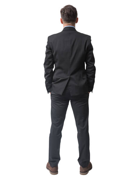 Rear view of businessman standing with hands in pockets stock photo