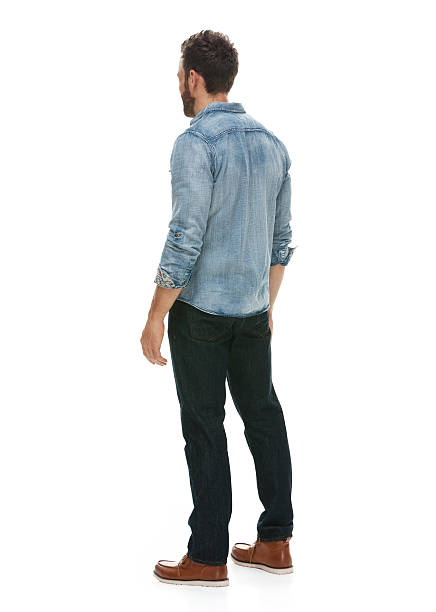 Rear view of casual man standing and looking away stock photo