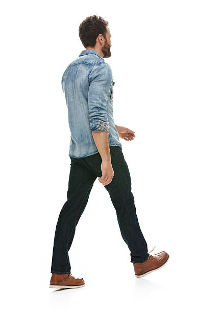Rear view of casual man walking stock photo