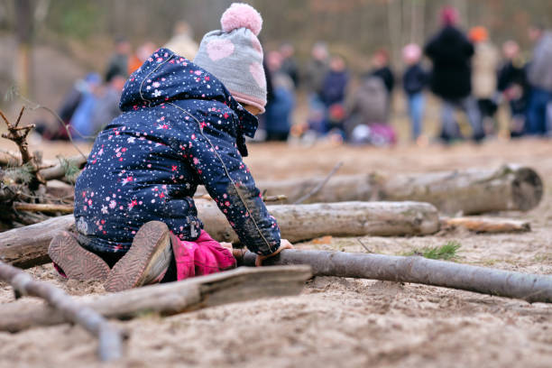 Rear view of child girl playing with wood in winter stock photo