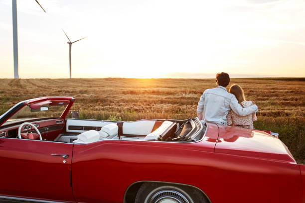 Rear view of couple hugging on a date at sunset stock photo