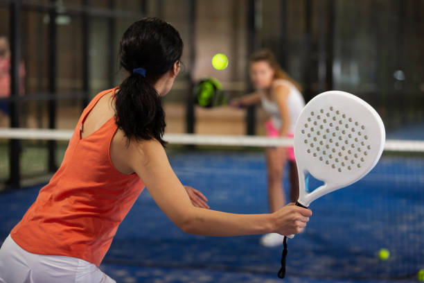 Rear view of girl with racket playing padel stock photo