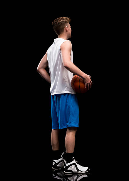 rear view of sports male holding basketball - basketball player back stockfoto's en -beelden