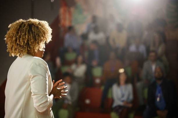 Rear view of the conference speaker giving talk at conference event. stock photo