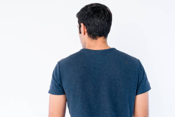 Rear view of young Persian man wearing blue shirt Studio shot of young handsome Persian man isolated against white background back stock pictures, royalty-free photos & images