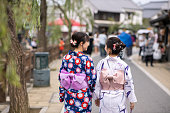 日本の伝統的な村を歩く浴衣の若い女性の背面図