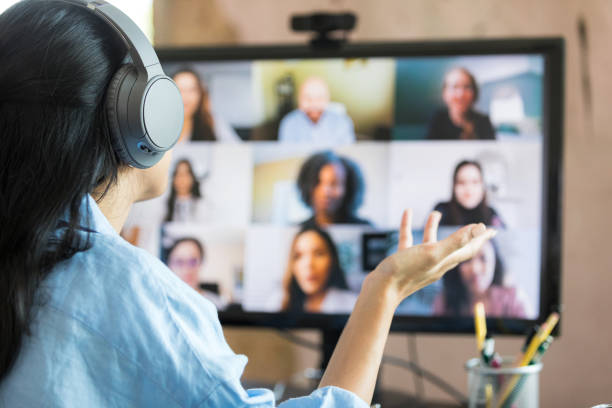 Rear view woman leading virtual meeting with multi-ethnic group stock photo