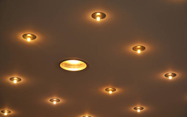 recessed lamps in a ceiling illuminated ceiling with recessed halogen lamps recession stock pictures, royalty-free photos & images