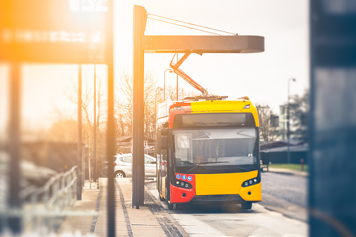 Electric public bus recharging at power station. Electric city busses for public transportation is a sustainable way to commute in cities, and the way forward to minimise air pollution. Image shot in Copenhagen, Denmark, but worldwide applicable.