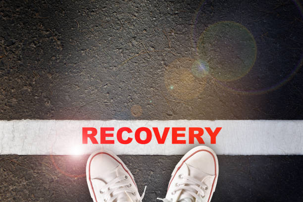 Recovery word written on asphalt road surface with white starting lines stock photo