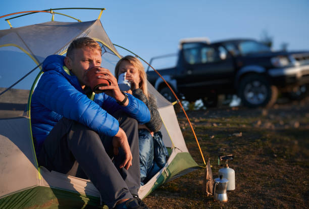 Recreation of campers pair in tent outdoors. stock photo