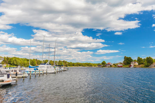 recreational boats in front of a small swedish island with old wooden houses - kalmar bildbanksfoton och bilder
