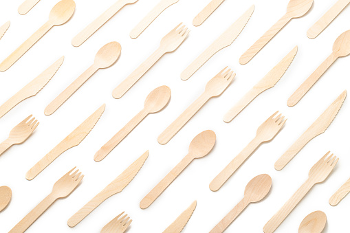 Top view of a background pattern made of eco friendly disposable cutlery on white background
