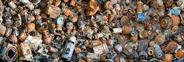 Recycling: Pile of electrical scrap motors and generators at junkyard Heap of disused electrical appliances, old and rusted generators and electric motors. They are waiting to be recycled in the circular economy. Close up and full frame image. View from above. circular economy stock pictures, royalty-free photos & images