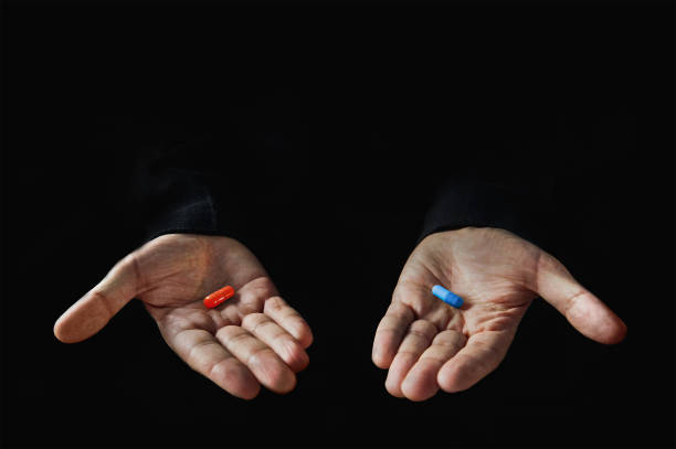 Red and blue pills on hand isolated Red and blue pills on hand isolated on black background pill stock pictures, royalty-free photos & images