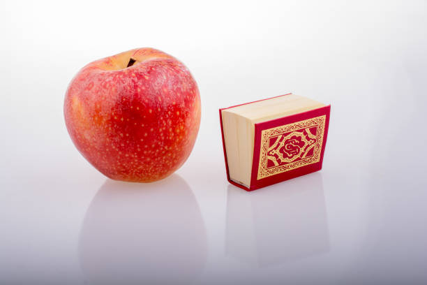 Red apple and Islamic Holy Book Quran Red apple and Islamic Holy Book Quran in mini size chatervate stock pictures, royalty-free photos & images