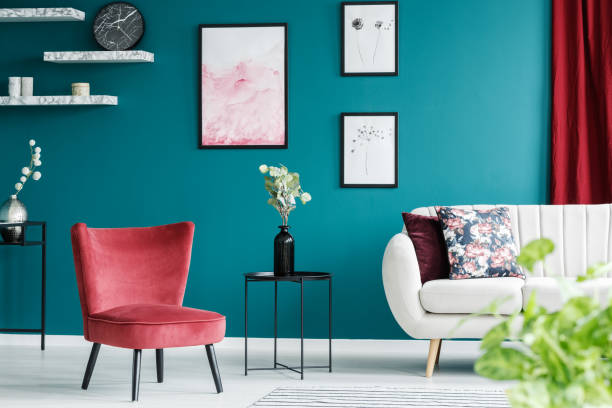 Red armchair in living room Red armchair, white sofa, paintings and black table in a green living room interior armchair photos stock pictures, royalty-free photos & images