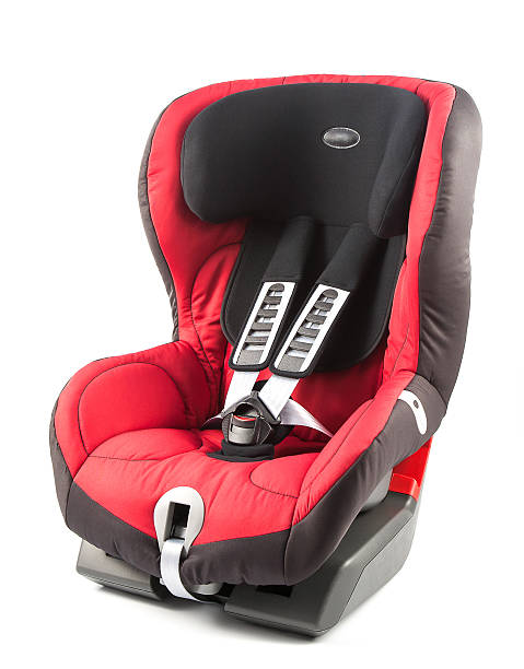 Red baby car seat The picture shows a red baby car seat on white background. The image was taken in studio, using studio lighting equipment. car safety seat stock pictures, royalty-free photos & images