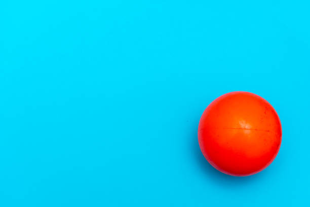 Red Ball hockey ball on a solid bright blue flat lay background symbolizing sports and activity with copy space. stock photo