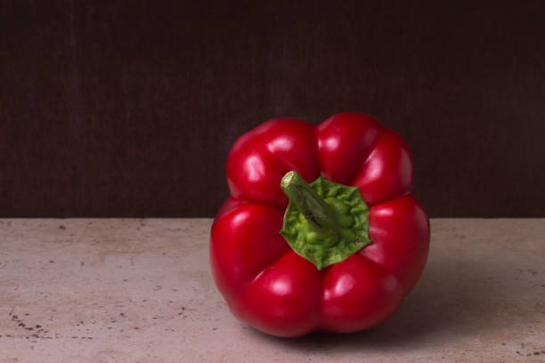 Red bell pepper on a rustic dark brown background stock photo
