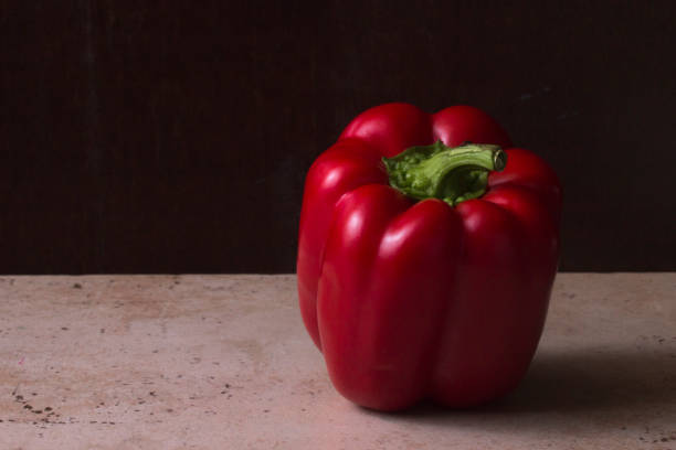Red bell pepper on a rustic dark brown background stock photo