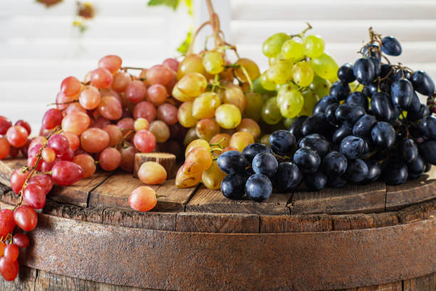 Red, black and green grape on wine barrel. stock photo