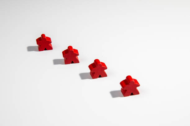Red board game wooden figures standing as a team stock photo