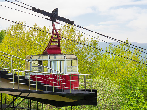 The red cab of the broken funicular of the old cable car, closed because of the coronavirus, against the background of the forest. Concept resorts are closed due to the pandemic.