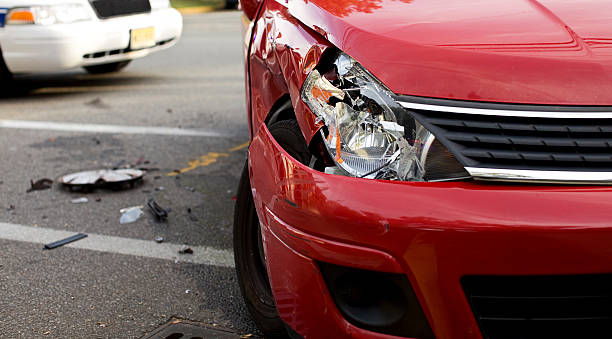 A red car with a damaged headlight after an accident stock photo
