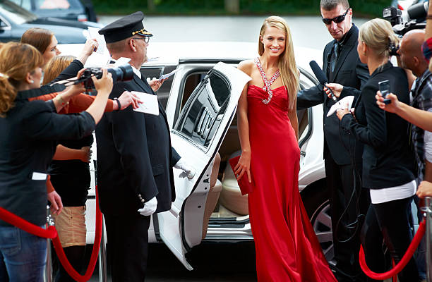 Red carpet glamour A stunning young starlet emerging from a limousine to fanfare and paparazzi demand on the red carpet actress stock pictures, royalty-free photos & images