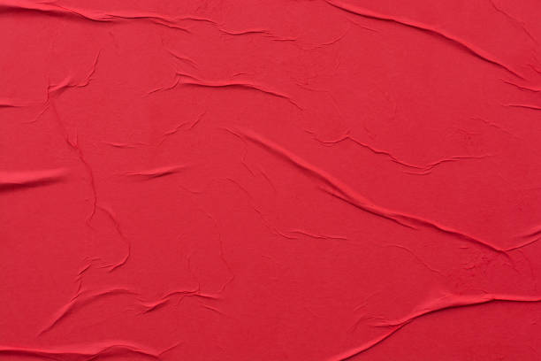 Red crumpled sheet of paper close-up. stock photo