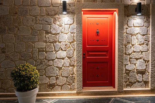 Red door on the monochrome stone wall