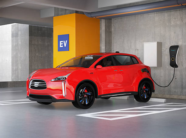 Red electric SUV recharging in parking garage stock photo