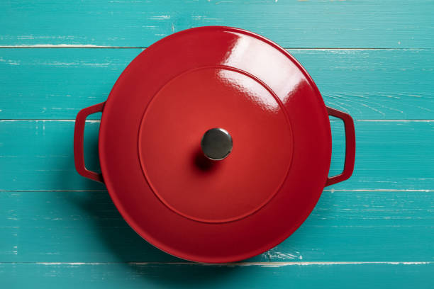 Red enameled cast iron pan on turquoise table stock photo