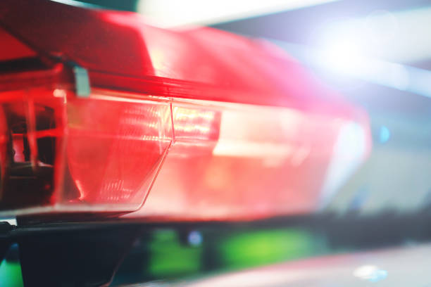 Red flasher on the police car at night. Red light flasher of a police car. Siren on police car flashing. Police red light and siren on the car in the street. stock photo