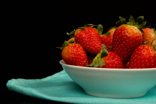 Red fresh strawberry in a bowl on black background. Red fresh strawberry in a bowl on black background ariane stock pictures, royalty-free photos & images