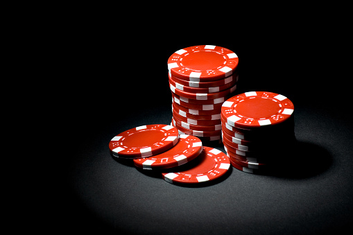 Red Gaming Chips In A Spotlight On Black Background Stock Photo ...