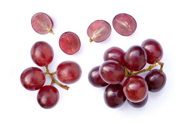 Red grapes fruit with half slice isolated on white background. Red grapes fruit with half slice isolated on white background. Top view. Flat lay. Grape pattern texture background. grape stock pictures, royalty-free photos & images