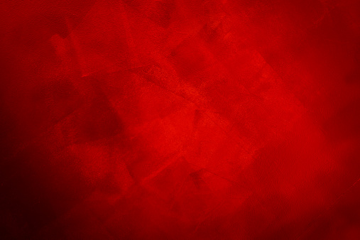 Mottled red background that is lighter in the center and more shadowy in the corners.  The red resembles paint applied by a roller in differing directions for a textured appearance.  It is uneven and varies in intensity, with the lower left corner in shadow.